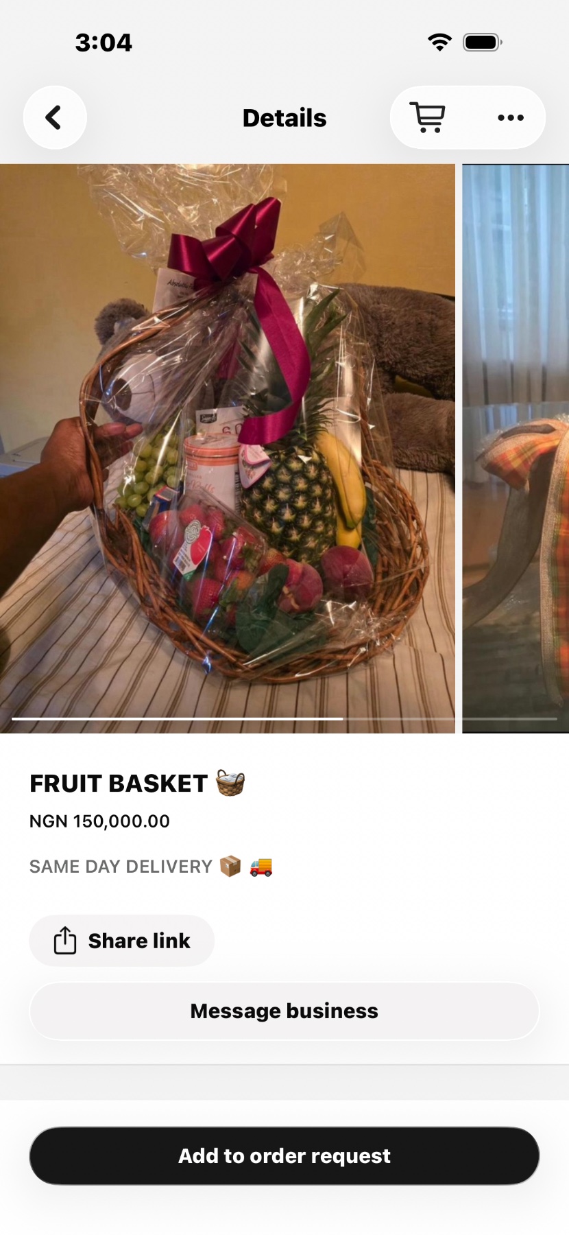 A fruit basket of grapes, strawberries, pineapple and banana wrapped with a ribbon