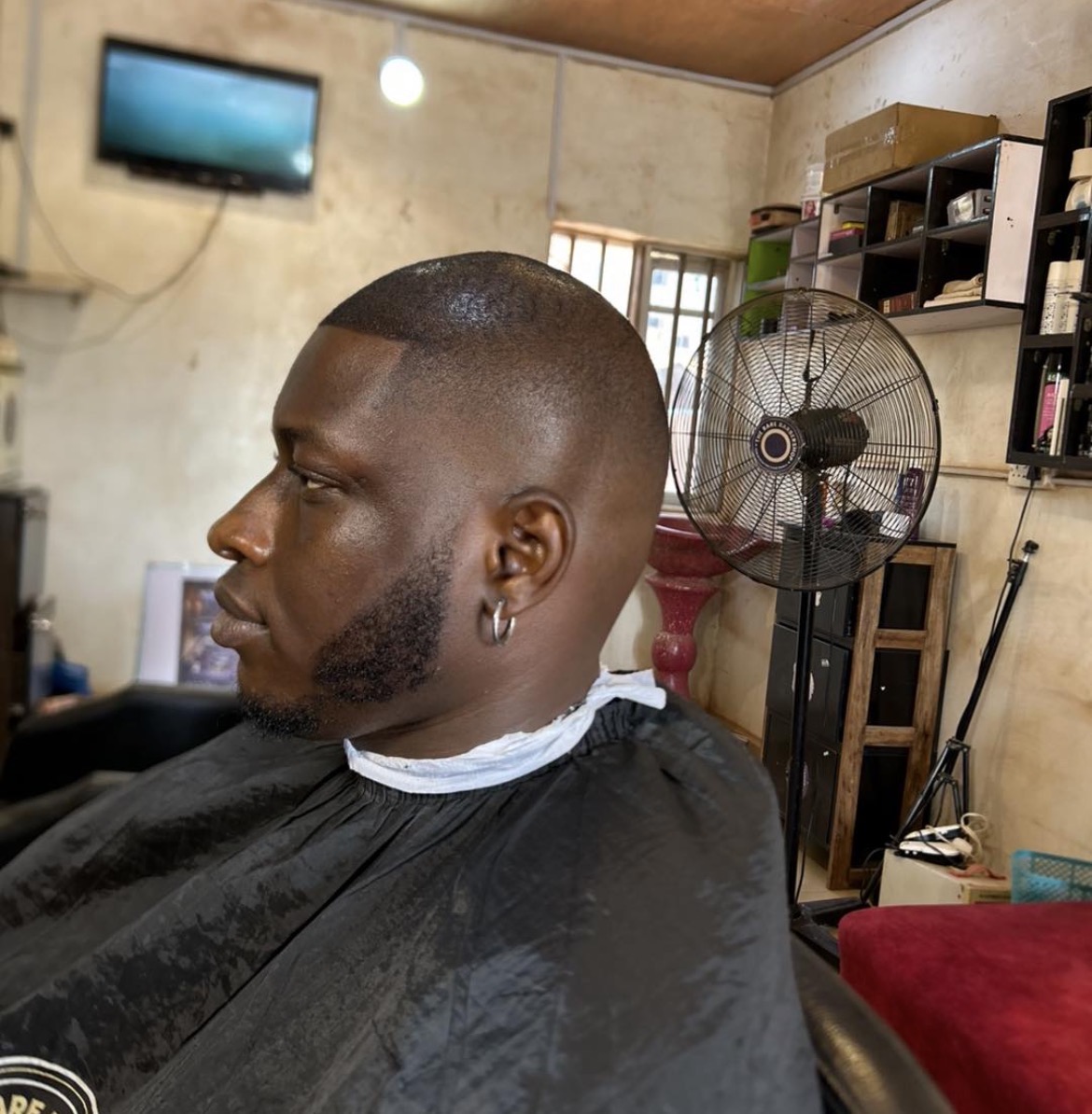 A client's fresh fade haircut with sharp line-up, shot inside the barbershop